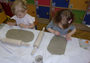 dziewczynki odrysowują kształt serca na przygotowanej wcześniej glinie