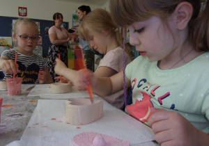 Juniorzy malują farbami wczesniej uformowane szkatułki z gliny