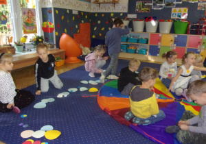 Juniorzy podczas zabawy z kropkami na dywanie