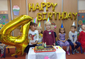 Solenizanci przy torcie urodzinowym - czterolatki