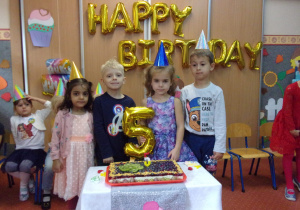 Solenizanci przy torcie urodzinowym - pięciolatki