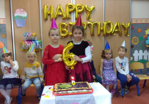 Solenizanci przy torcie urodzinowym - sześciolatki