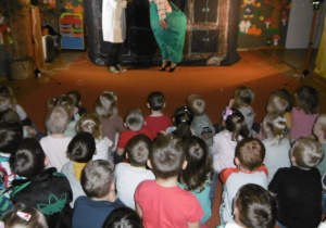 dzieci oglądają przedstawienie teatru WidziMiSię, w tle dekoracja bajki „Co zdarzyć się może w starej komodzie”