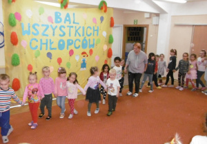 dzieci podczas zabawy tanecznej na sali gimnastycznej, w tle dekoracja z okazji Dnia Chłopca