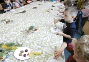 dzieci przy stole w Centrum Zajęć Pozaszkolnych podczas tworzenia pracy plastycznej