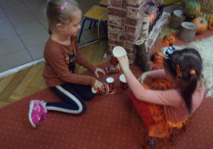 dziewczynki próbują ułożyć wieżę z dynowych kubków
