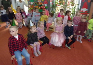 dzieci obchodzace urodziny w listopadzie nna krzesełkach na sali gimnastycznej w czapeczkach urodzinowych