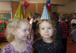 dziewczynki obchodzące urodziny w czapeczkach urodzinowych