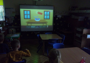 Juniorzy oglądają film na tablicy interaktywnej