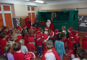 dzieci ubrane na czerwono rozmawiają z Mikołajem