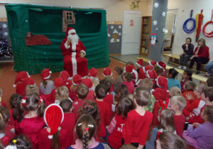 dzieci ubrane na czerwono rozmawiają z Mikołajem