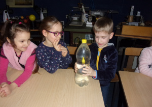 Juniorzy wykonują eksperymenty z butelką z wodą