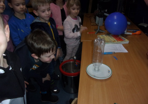 Juniorzy wykonują eksperymenty z butelką i talerzykiem