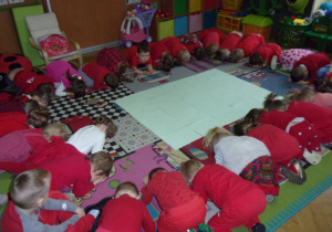 zabawy walentynkowe - Smyki i Tuptusie ubrane na czerwono w kole na dywanie