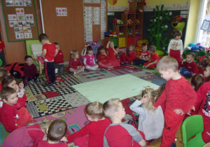 zabawy walentynkowe - Smyki i Tuptusie ubrane na czerwono w kole na dywanie