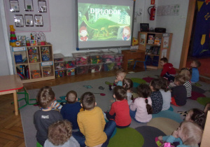 Tuptusie i Smyki oglądają na tablicy interaktywnej film o dinozaurach