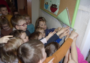 dzieci szukają w przedszkolu kopert z zadaniami do wykonania
