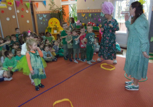 dzieci ubrane na zielono na sali ginastycznej ustawione w rzędach