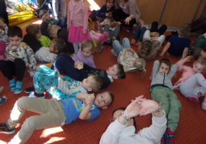 dzieci w pozycji leżącej podczas zabawy urodzinowej na sali gimnastycznej