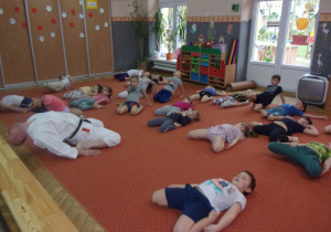 Juniorzy leżą na dywanie z podwiniętymi nogami