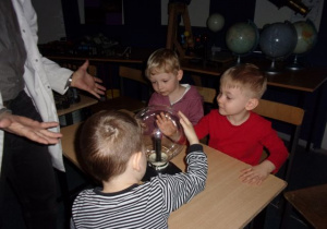 chłopcy dotykają szklanej kuli