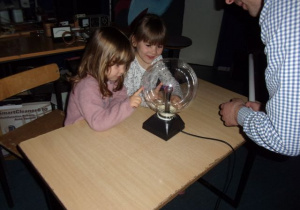dziewczynki dotykają szklanej kuli