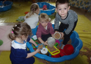 dzieci podczas zabawy materialami sypkimi w baseniku