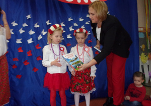 dziewczynki otrzymują nagrody książkowe