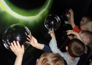 dzieci dotykają szklanych kuli