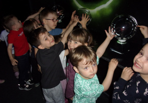 dzieci dotykają szklanych kuli