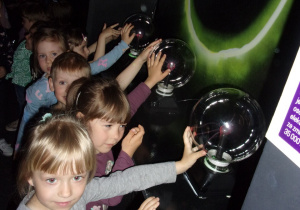 dzieci dotykają szklanych kul