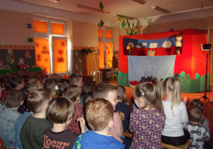 dzieci na tle dekoracji teatrzyku "WidziMiSię" do przedstawienia "Konik Garbusek"