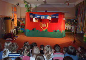 dzieci na tle dekoracji teatrzyku "WidziMiSię" do przedstawienia "Konik Garbusek"