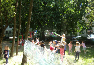zabawa z bańkami mydlanymi w ogrodzie przedszkolnym