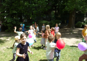 dzieci bawią się balonami w ogrodzie przedszkolnym