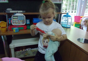 dziewczynka bawi się lalką