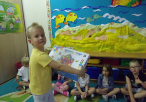 chłopiec trzyma w ręku pudełko z klockami