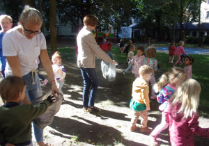Tuptusie i Smyki zbierają śmieci w ogrodzie przedszkolnym
