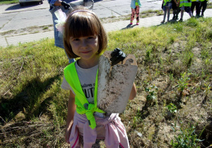dziewczynka zbiera śmieci w okolicy przedszkola