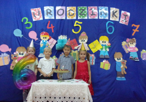 sześciolatki na tle dekoracji urodzinkowej