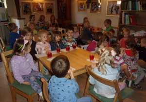 Juniorzy i Żaczki w Baśniowej Kawiarence częstują się napojem i ciasteczkiem