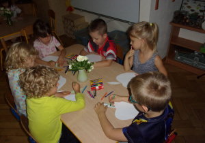 dzieci kolorują sylwety jabłek przy stolikach