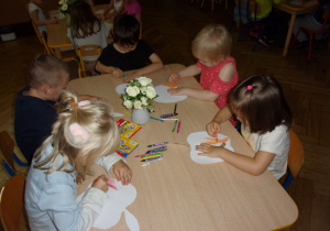 dzieci kolorują sylwety jabłek przy stolikach
