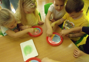 dzieci uczestniczą w eksperymencie z barwnikami spożywczymi