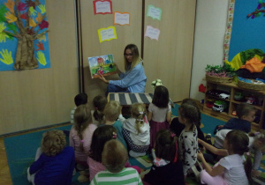 mama Marysi w Żaczkach czyta dzieciom książkę