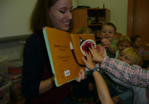 Smyki i Tuptusie podczas czytania książki przez Panią z biblioteki