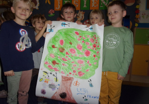 piątka dzieci przedstawia pracę wykonaną grupowo