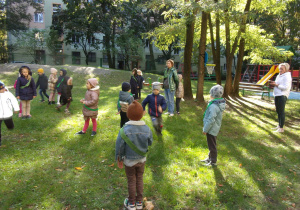 dzieci w szarfach biorą udział w zabawie ruchowej w ogrodzie przedszkolnym