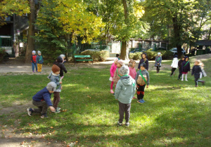 dzieci w szarfach biorą udział w zabawie ruchowej w ogrodzie przedszkolnym