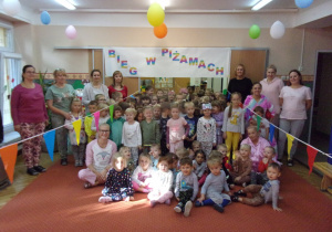 zdjęcie grupowe dzieci z całego przedszkola na tle napisu "Bieg w piżamach"